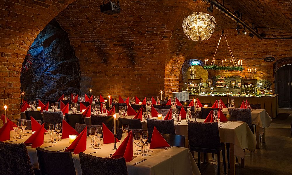Dukade bord för julbord i tegelvalven på Vaxholms Kastell i Stockholms skärgård.